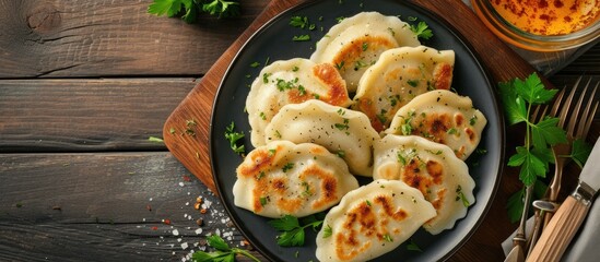 A top view of a plate filled with traditional Polish dumplings, known as pierogi, placed on a...