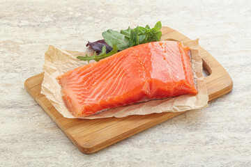 Raw salmon fillet over board