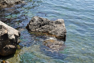 Seascape. Waves wash over a large stone by the sea