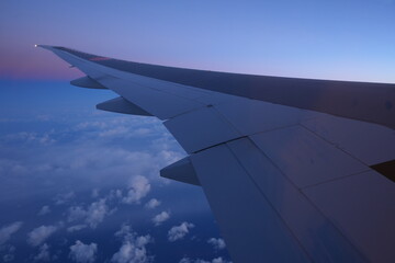 Obraz premium Sunrise and Wing of Aircraft from Window - 飛行機の翼と朝日