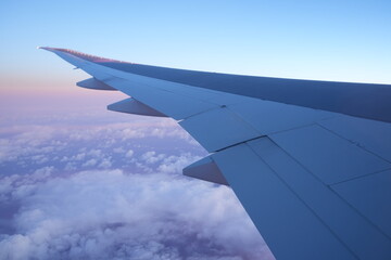 Obraz premium Sunrise and Wing of Aircraft from Window - 飛行機の翼と朝日