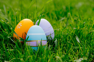 Happy Easter. Easter eggs on grass on a sunny spring day - Easter decoration, banner, panorama, background with copy space for text.