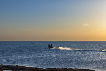 Fishermen on boats in the Mediterranean sea at sunset
