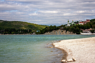 View of the church on the mountain. View of Lake Abrau-Durso from the shore. In the village of Abrau-Durso, on the mountain stands the Church of Blessed Xenia of Petersburg.