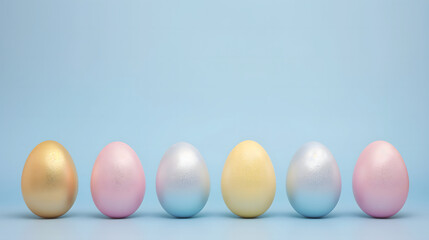 Metallic glossy pastel Easter eggs on a plain pastel blue background with blank space for text at the upper part of the image.