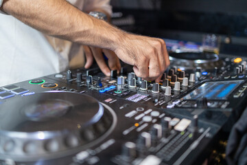 Obraz premium DJ's Hands Adjusting Music Mixer at Event