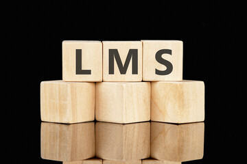 LMS (Learning Management System) on wooden cubes on a glossy black background