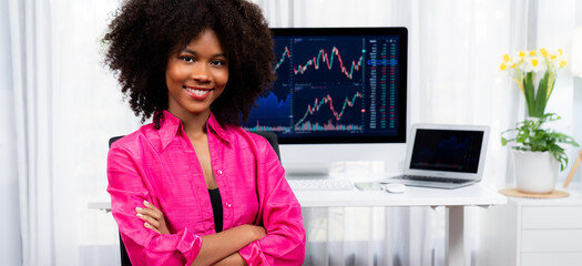 Analytical young African American businesswoman, a specialist in successful stock exchange trading,...
