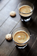 Two Glasses Of Coffee on dark wooden background. Close up.
