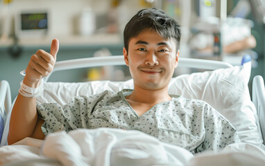 Asian Man Recovering from in Bed in the hospital showing a thumbs up sign