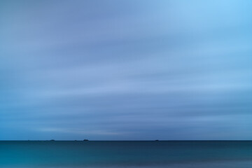 Diminutive Islands on the Horizon of Stormy Seascape with Long Exposure