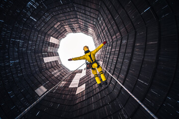 Rope access specialist in a cooling tower. A worker inspects the building