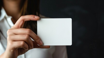 Obraz premium Woman holding a white card, suitable for business or communication concepts