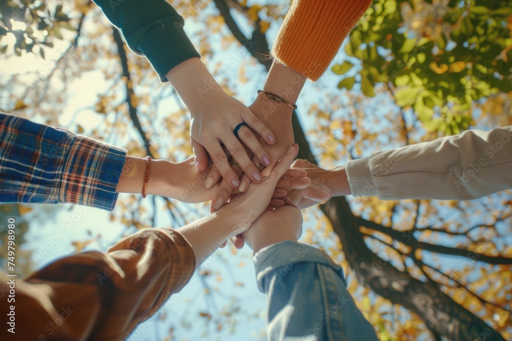 Poster A group of people joining hands in unity. Perfect for team building concepts