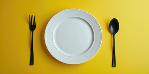 White plate with silver fork and spoon, suitable for food photography or restaurant promotions