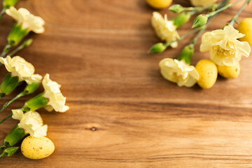 Yellow flowers and yellow colored eggs on a background of brown wood. Layout. Mockups. Springs background. Easter background