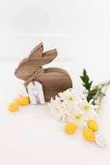 Yellow, white, and pastel blue colored eggs and white flowers and Easter bunny on a white background. Food and chrysanthemums on a clear white background. Mockups. Layout. Easter minimalist background