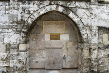An old water tap with Arabic inscriptions written above it in Istanbul, Eyüp Sultan, Turkey