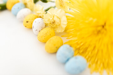 Yellow and white colored eggs and yellow flowers on a white background. Food on a clear white...