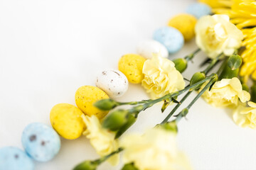 Obraz na płótnie Canvas Easter eggs and yellow daffodils close up on a white clear background. Layout. Mockup. Spring background. Easter minimalist card