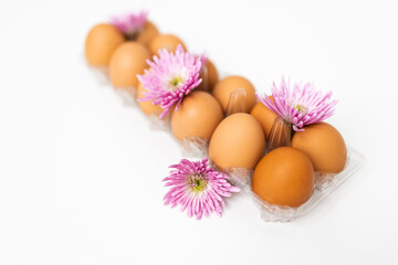 Large brown organic eggs with pink flowers. Food on a clear white background. Mockups. Layout.