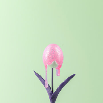 Creative Easter concept. Tulip with a bud in the form of an egg with glitter paint running down it.