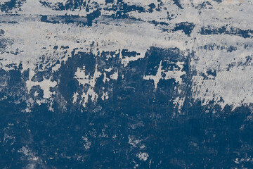 Old black grunge background. White paint on blue wall
