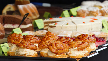Wreaths with yolk cream and strawberries at the table of local confectionery stand.