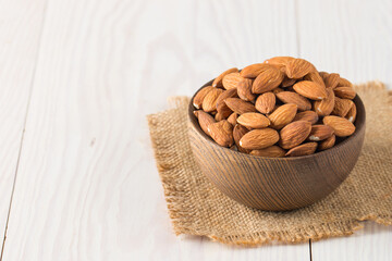 Raw peeled almonds in brown bowl