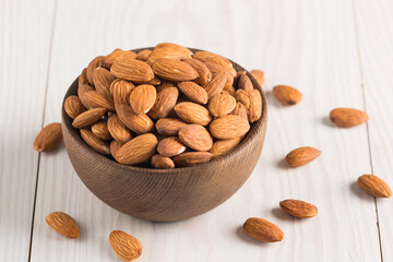 Raw peeled almonds in brown bowl