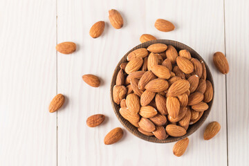 Raw peeled almonds in brown bowl