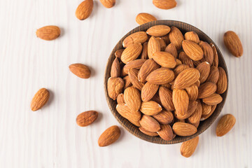 Raw peeled almonds in brown bowl