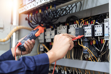 Electrician engineer work tester measuring voltage and current of power electric line in electical cabinet control , concept check the operation of the electrical system .	
 - obrazy, fototapety, plakaty