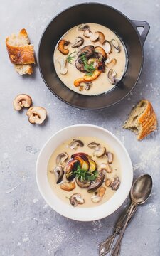 Mushroom soup served with fresh and fried champignons and rosemary over white background