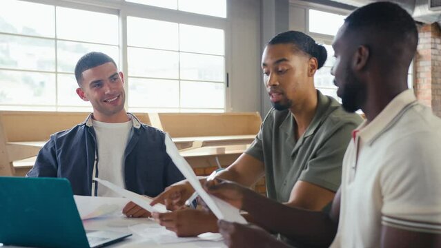 Three Young Businessmen Meeting In Modern Office Sitting At Table With Laptop Collaborating On Project Together - Shot In Slow Motion