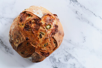 Whole loaf of Sourdough bread on marble table.