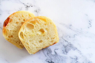 A slice of cheddar sourdough bread on marble table