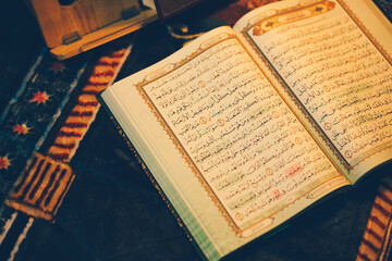 The Quran was opened for reading and had a dim golden glow. Selective focus. The concept of Islam.