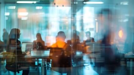 Blurred office with people working behind glass wall. Productivity in modern office space.