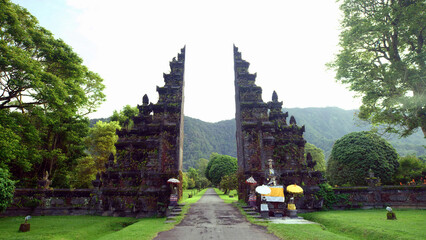 Traditional Balinese Hindu gate at rainy summer day with clouds - Candi Bentar, Bedugul in Bali, Indonesia - obrazy, fototapety, plakaty