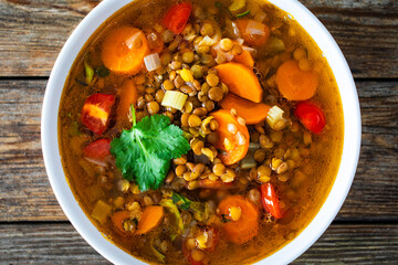 Fresh vegetable soup with lentil on wooden table
