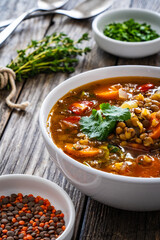 Fresh vegetable soup with lentil on wooden table
