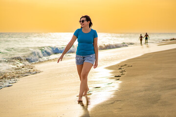 Beautiful woman walking on sunny beach Santa Maria, Sal Island, Cape Verde
