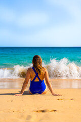 Fototapeta na wymiar Beautiful woman sitting and sunbathing on the beach Santa Maria, Cape Verde, Sal Island 