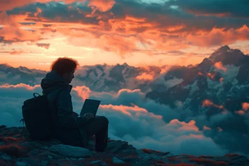 Gordijnen Person working on laptop on top of mountain at beautiful sunset overlooking stunning landscape © VICHIZH