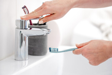 Woman'S Hand Placed Toothbrush Under Tap For Oral Hygiene