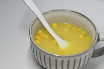 スープボウルにスプーンの入ったコーンスープ