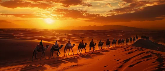  A caravan of camels crossing the vast dunes of the Sahara Desert at sunset, the golden sands stretching to the horizon © Lemar
