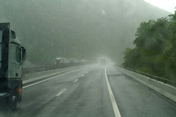 Heavy rain on a highway with cars moving along it