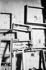 black and white picture of a lost place with many frames at the wall